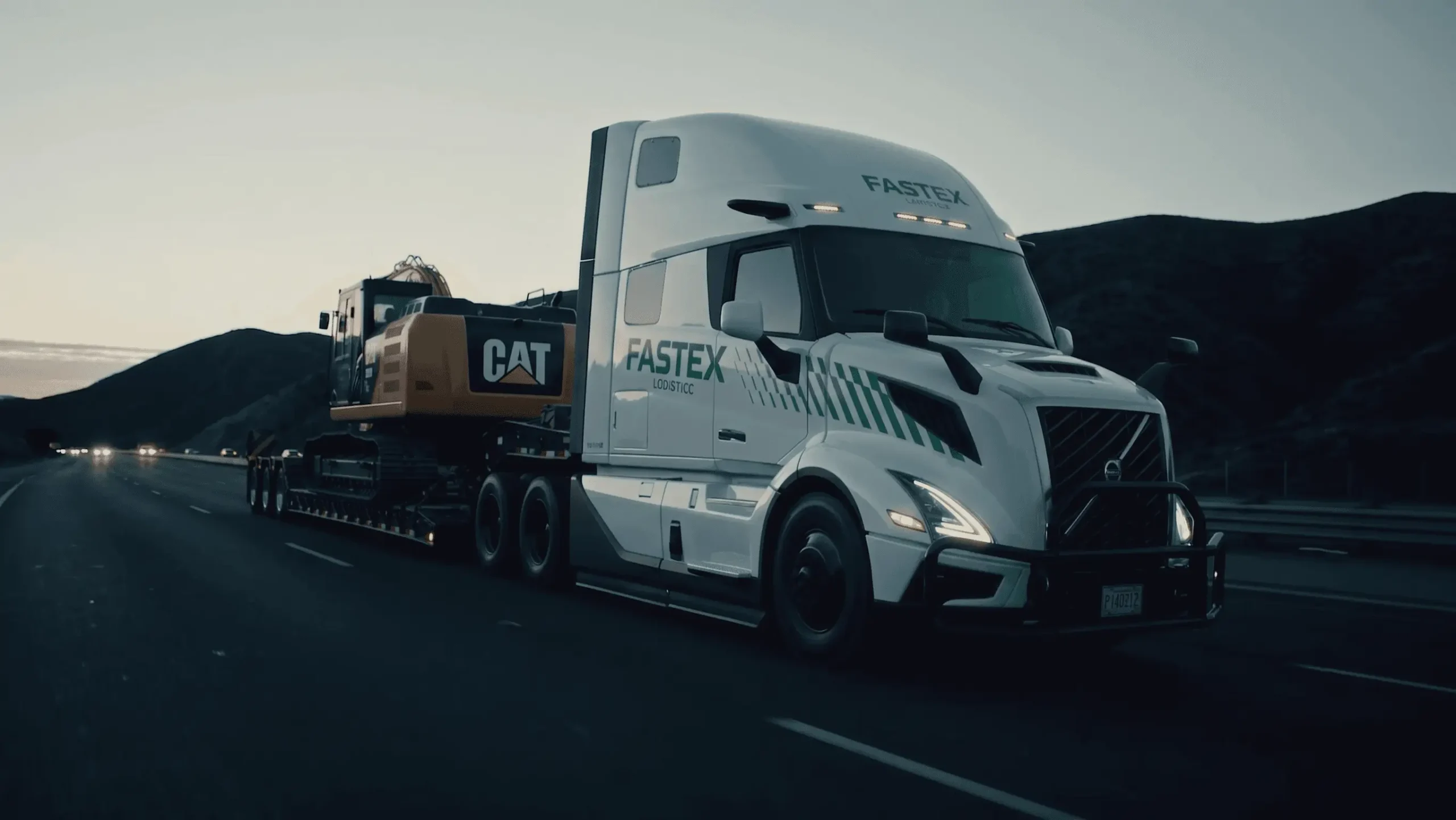 Fastex Logistics flatbed hauling a CAT excavator on the highway